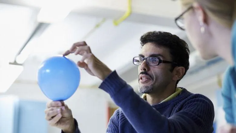 Student holding a balloon in a lab