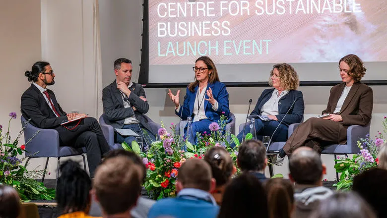 Five speakers sit in front of an audience at the launch of the Centre for Sustainable Business