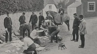 Black and White image of a group of men in Europe looking at pages