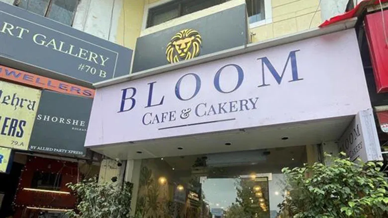 The frontage of Parth's Bakery Bloom. It is a white sign with large blue lettering.