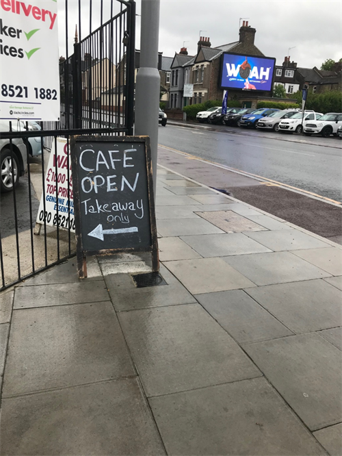 Photo of a blackboard with the writing "cafe open take away only" written on it in white chalk. Taken on Shernhall Street Walthamstow