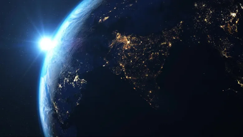 A view of earth from space in low lighting with the lights of cities visible