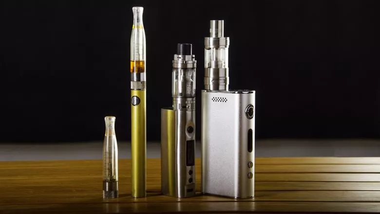 Three vapes on a wooden table