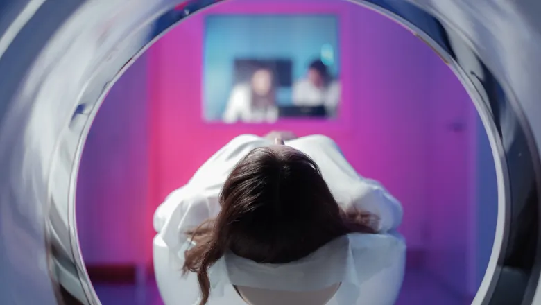 Top of a girls head lying down in an MRI machine