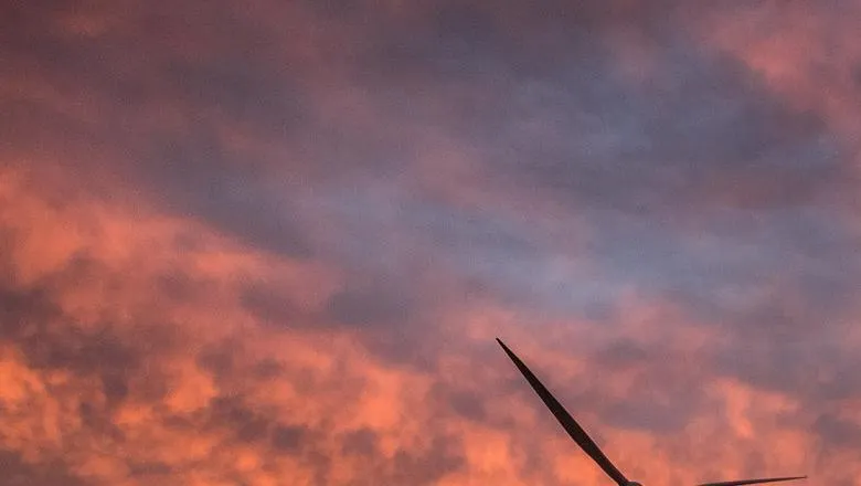 A windfarm is silhouetted against a red sky