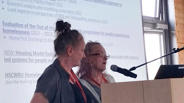 Michelle Cornes and Jo Coombes speaking at a conference lectern