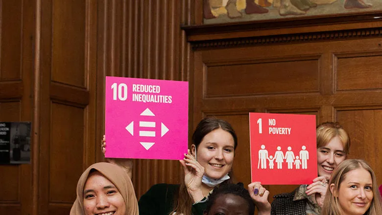 Conference participants holding up SDG icons.