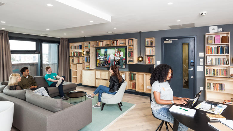 Group of five students sitting in the living room of accommodation