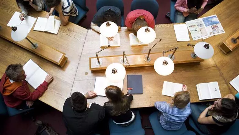 Birds-eye view of students in discussion at a library table