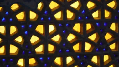 Image of stained glass with yellow and blue patterns.