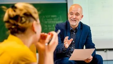Student and teacher discussing work in the classroom