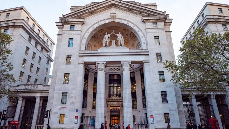 The exterior of Bush House in London. A grand stone building with a portico and columns around the entrance.