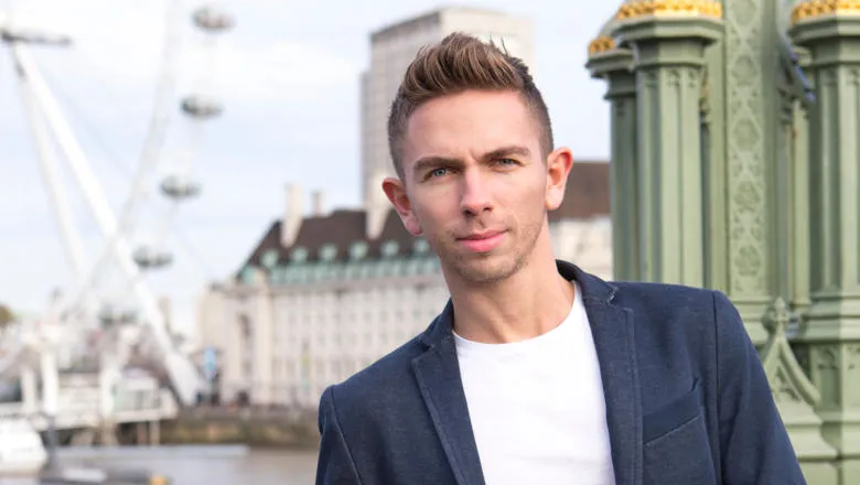 Darren Burn standing on the Thames waterfront, with the London Eye in the background