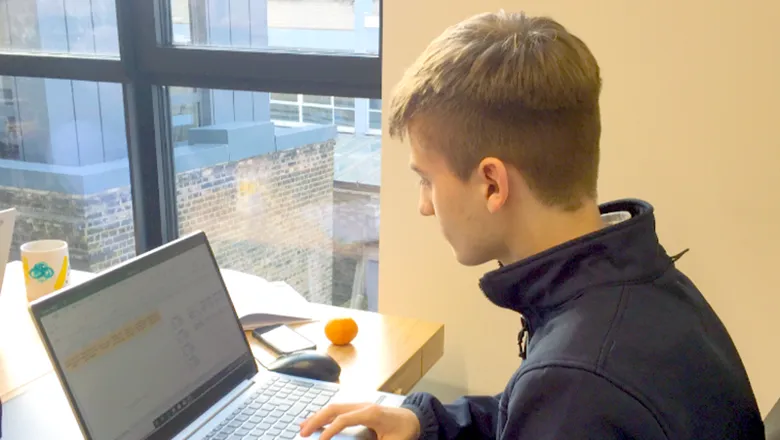 Student Dominic Gibbs sits at laptop computer