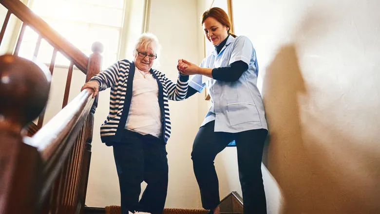 Image of a Nurse Helping A Senior Women Down the Stairs