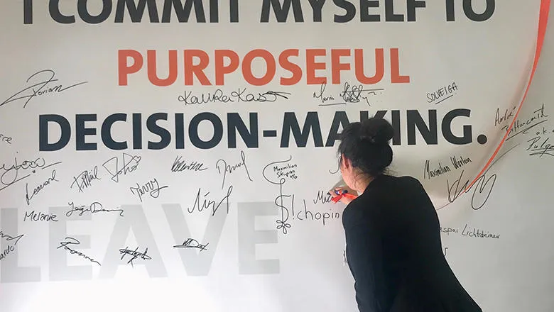 Micaela Mihov signing a declaration of 'I commit myself to purposeful decision-making' at the St. Gallen Symposium. 