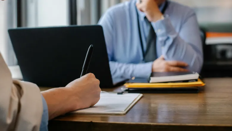 Woman filling job application form in office with boss