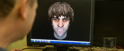 Man looking at computer screen showing avatar
