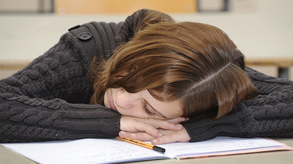 Young woman asleep with her head resting on a desk