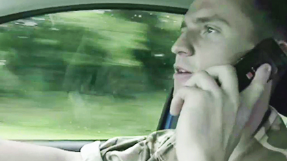 Still from the Grim Reaper video showing an army officer driving while talking on a mobile phone