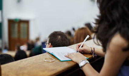 A student taking notes in a lecture