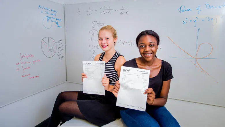 Two students holding their results.