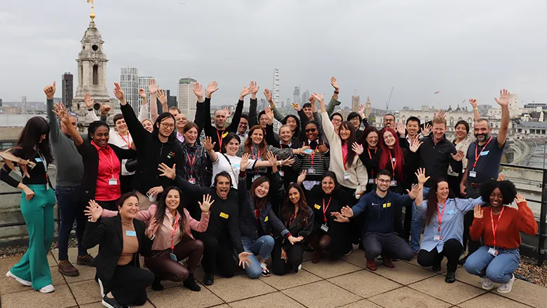 A group of people wave to the camera
