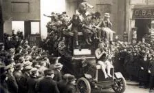 image of students in costumes on a vehicle exiting onto the Strand through the old Strand entrance 