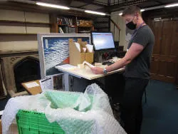 Staff member preparing items for despatch for a digitisation project