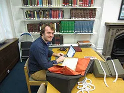 MA History intern in Special Collections consulting a manuscript