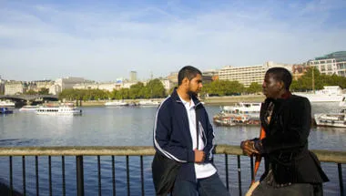 Two men standing on a bridge
