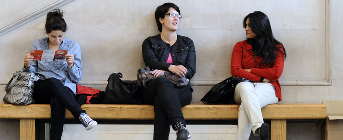 three students on bench in foyer
