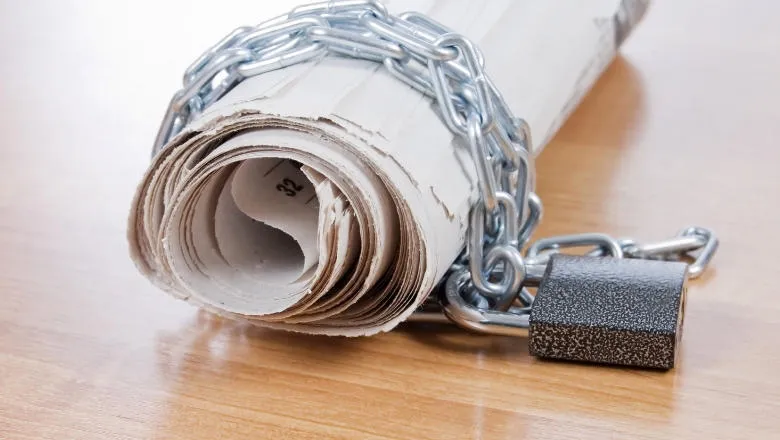 rolled up newspaper, wrapped in chains