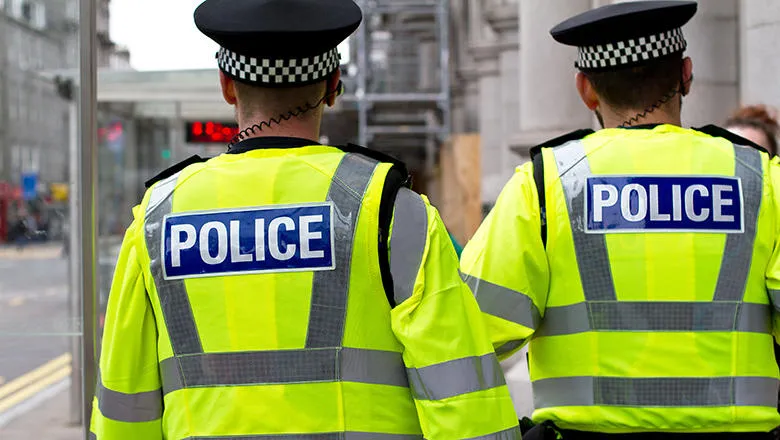 An photo showing the backs of two policemen.