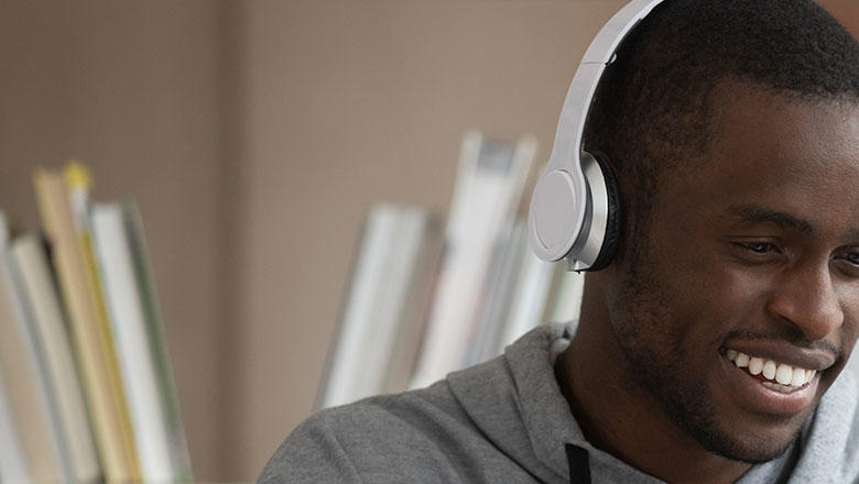 Man wearing headphones using laptop.