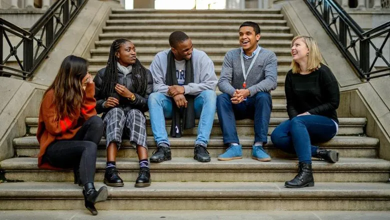 Group of students sat on stairs talking