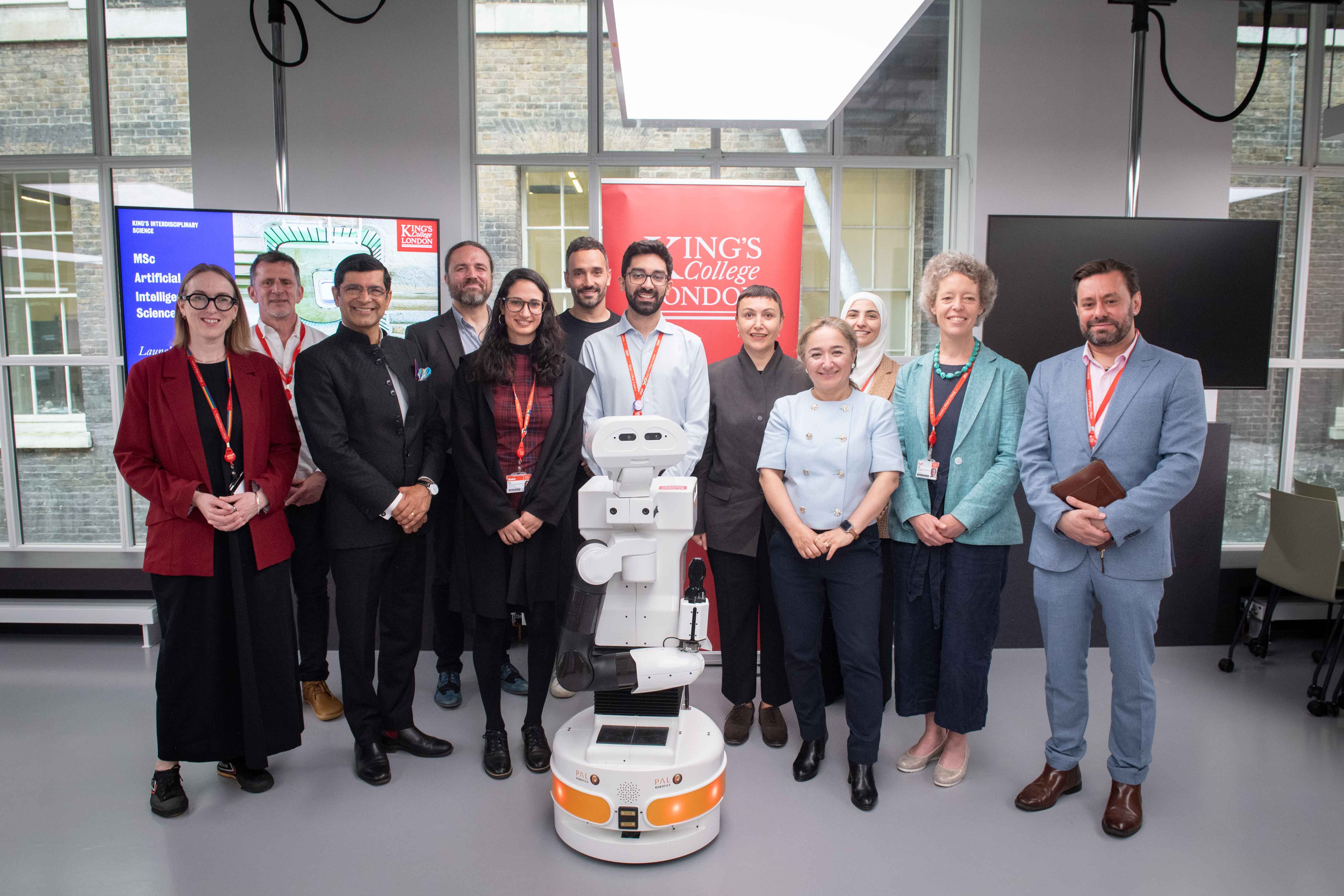 People standing next to a robot