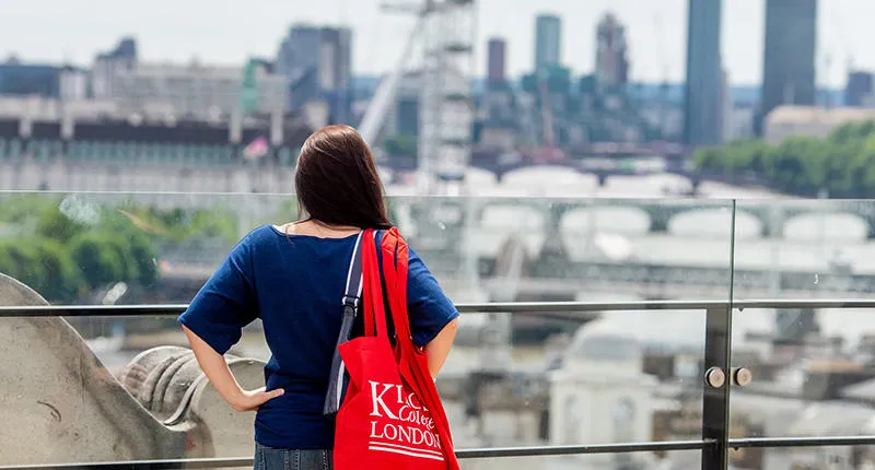 A student standing on the roof deck of Bush House looking out over London.