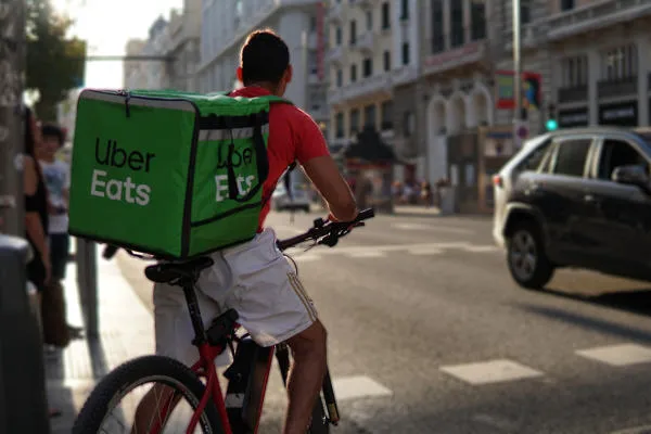An Uber Eats delivery person on a bicycle on a street
