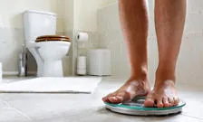 Person standing on weighing scales in a bathroom