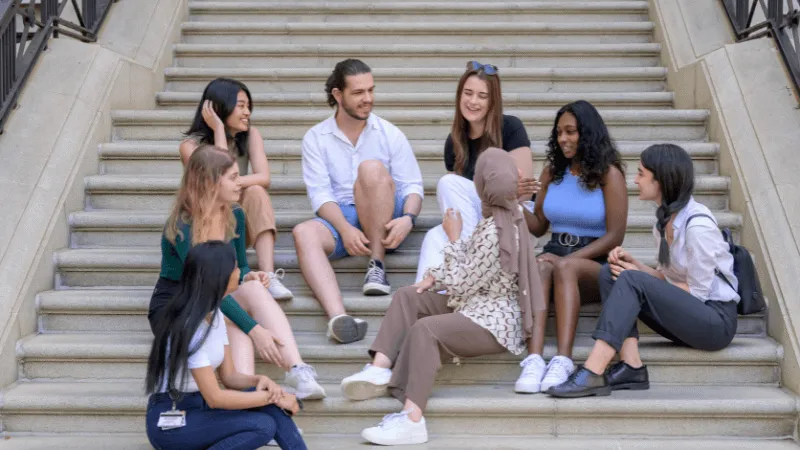 A group of King's students sitting and chatting on some stairs