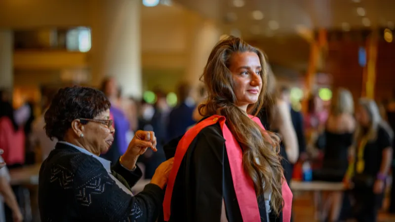 A King's student preparing their robes for graduation