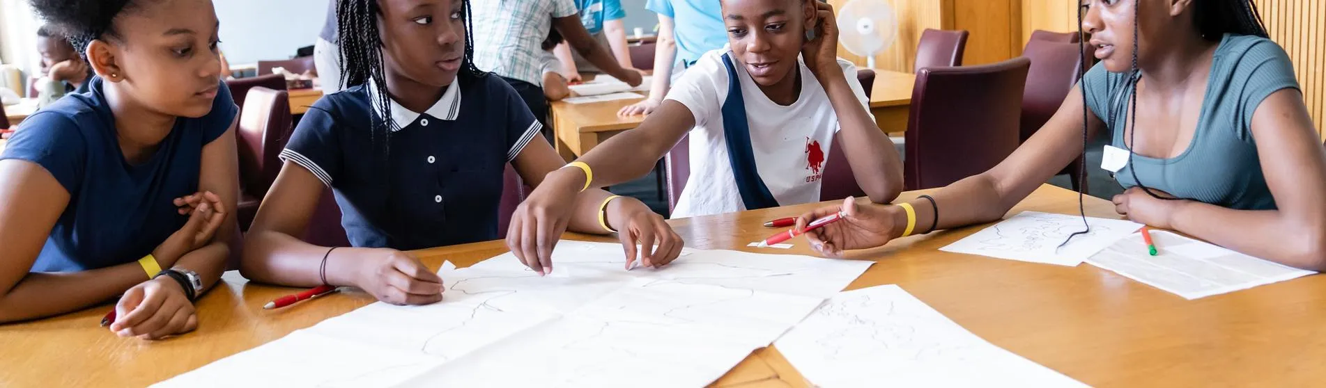 Four young people sit around a table working together