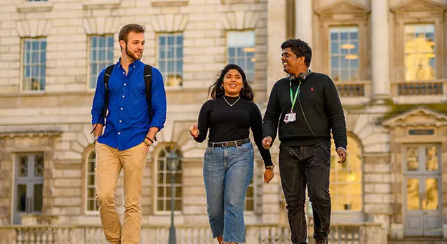 Three students walking and talking.