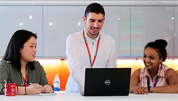 Three colleagues at a computer (two females and one male)