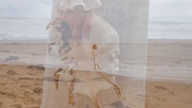 Woman walking along a sandy beach.