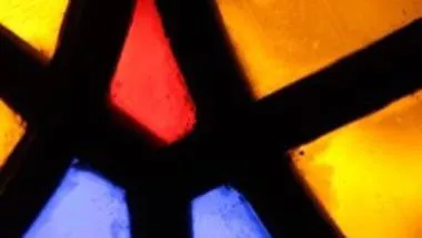 close up image of a stained glass window with a red, yellow and blue design