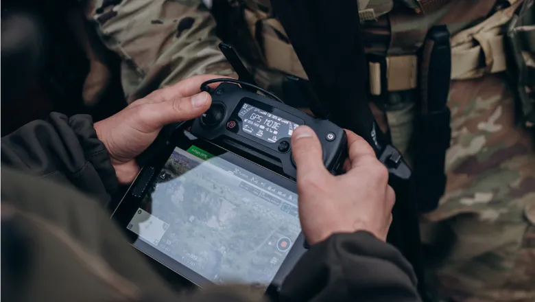 Military men using a tablet to operate a drone