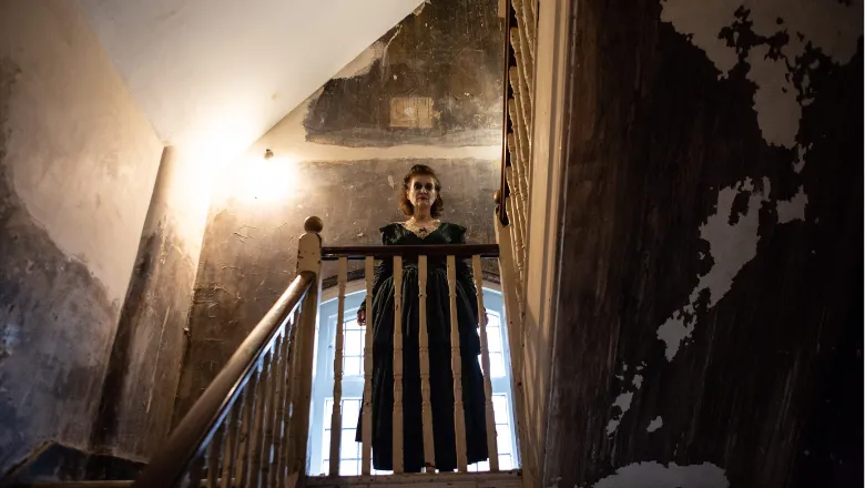 Character named the ghost of Molly Perkins standing in a stairwell.