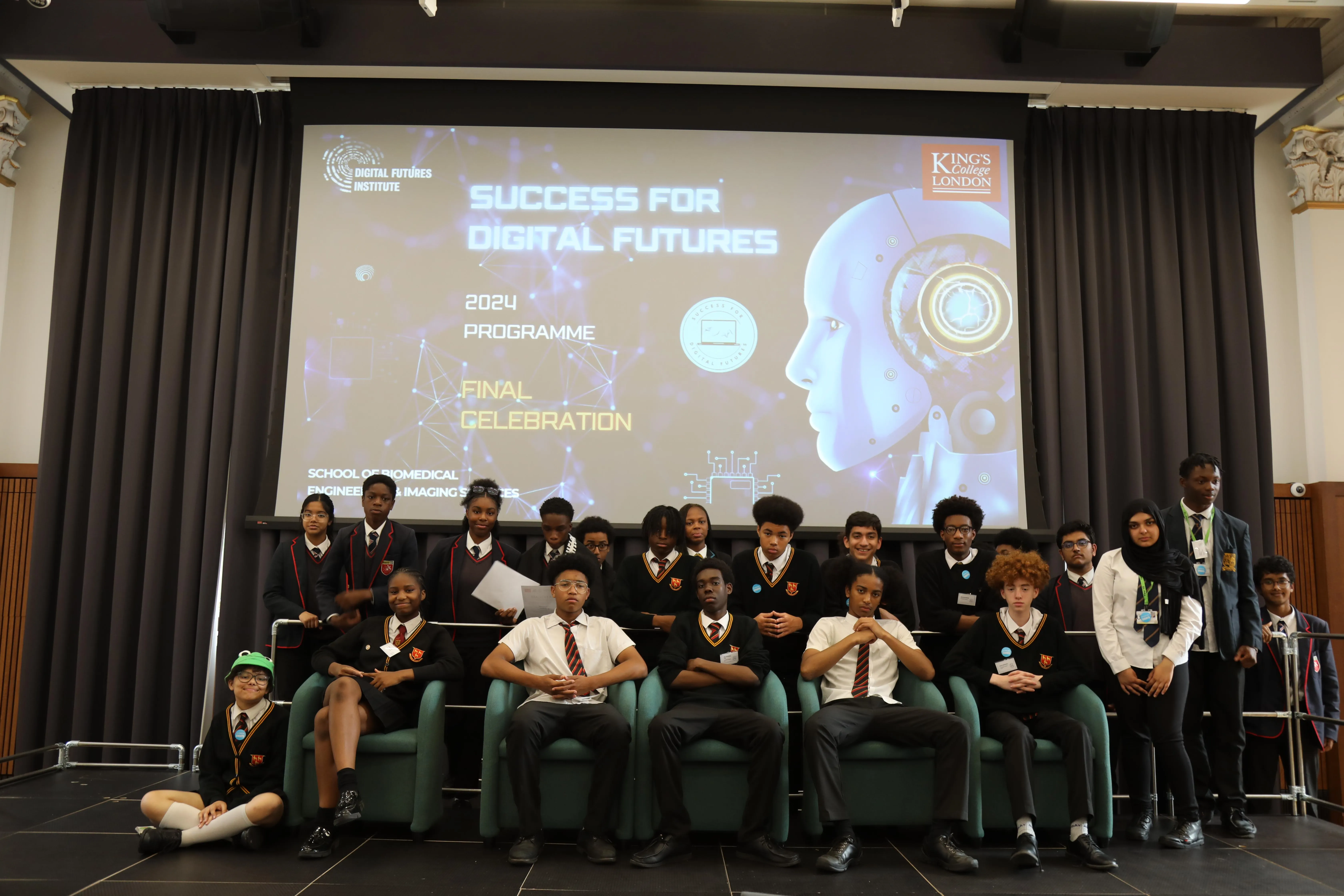 Group of students standing on a stage in front of a projector